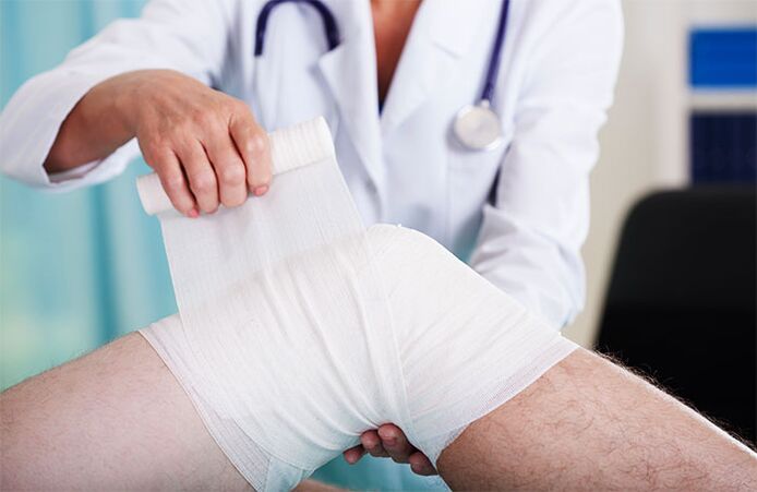 médico enfaixando a articulação do joelho com artrose